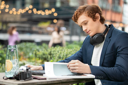 WH-1000XM4 headphones around the neck in a café