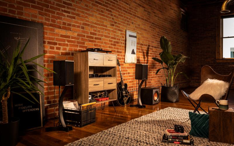 Klipsch speakers with a guitar and wooden shelf
